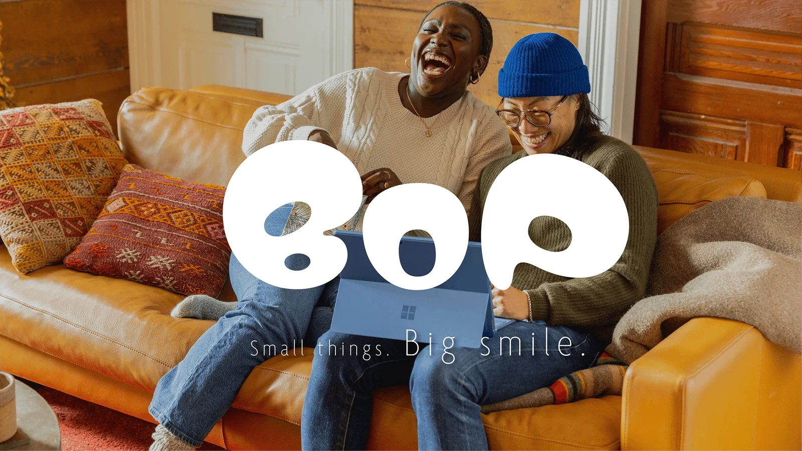 BOP logo over two friends laughing on a sofa. Small things. Big smile.